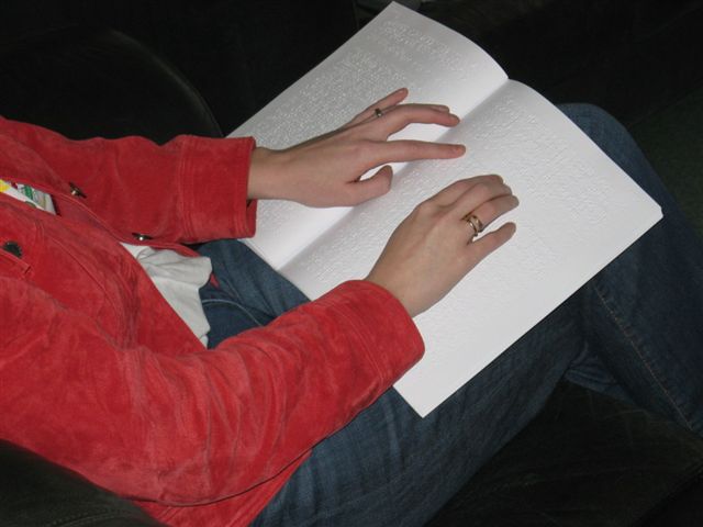 Hand van Kim leest braille