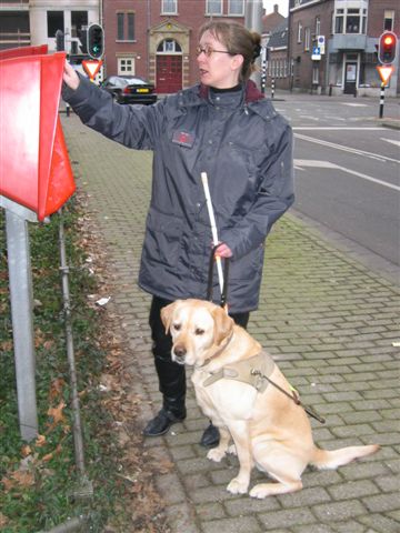 Kim met geleidehond bij de brievenbus